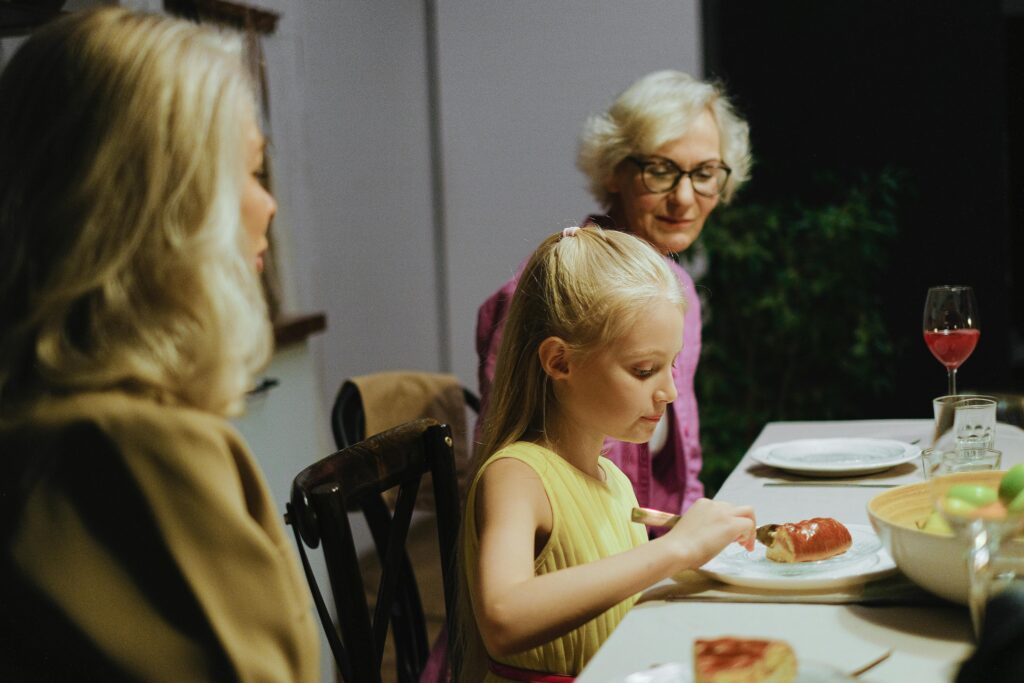 A warm family dinner with three generations enjoying a meal together indoors.