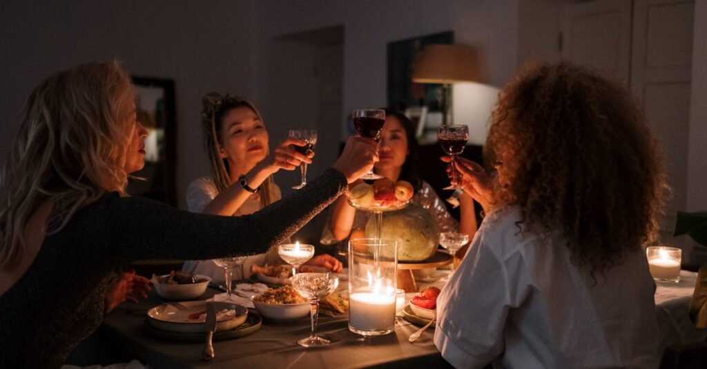 A group of diverse friends clinking wine glasses during an intimate dinner gathering indoors.