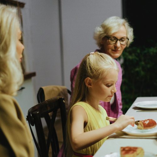 A warm family dinner with three generations enjoying a meal together indoors.